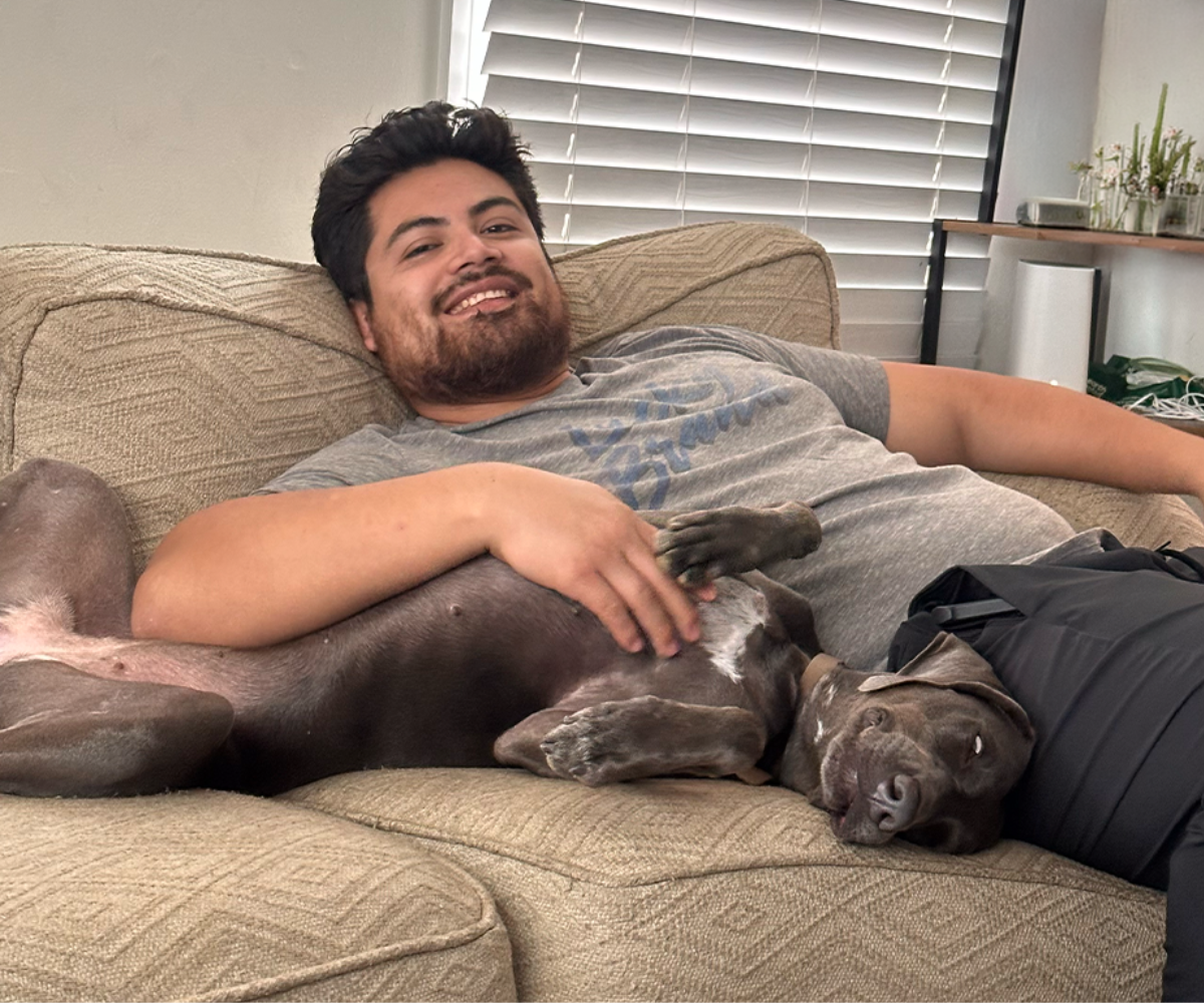 Owner of the Doggo Scoop on couch cuddling with dog.
